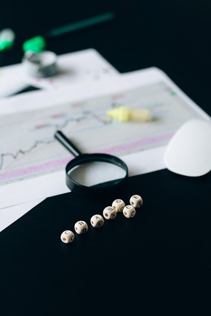 Conceptual still life of business documents, charts, and magnifying glass focusing on risk analysis.